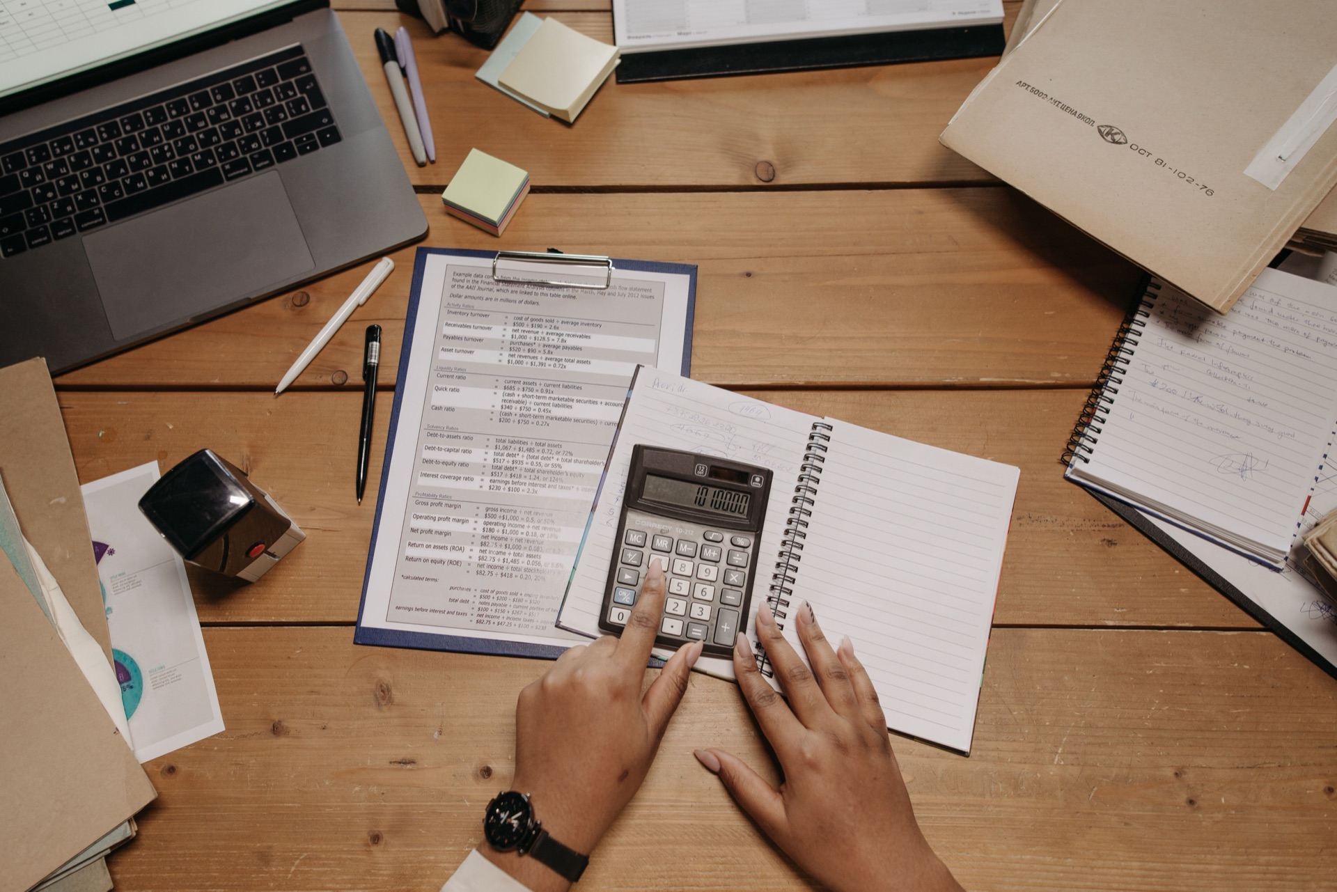 A desk buried in paperwork and handwritten notes